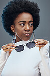 Fashion, beauty and black woman with sunglasses in studio for cosmetics, makeup and luxury style. Fashion model, designer brand and confident girl with stylish accessories, trendy and edgy jewellery