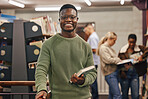 Black man, book and portrait in library with smile, research and studying at college for education. African gen z student, happy and university for books, learning or vision for future career goal