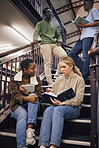 College student group, stairs and reading for study, research and discussion for exam, test or education. Students team, diversity and books for success, goals and focus at university with teamwork