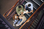 Above, student group and stairs for reading together, studying and research for exam, test or education. Students, diversity and teamwork for success, goals and motivation at college, campus or focus