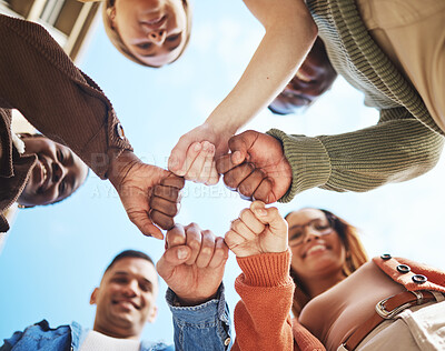 Buy stock photo Group of friends, hands bump in huddle and group diversity, team building circle from below. Friendship, happiness and university students in fist bump, men and women smile together on college campus