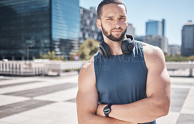 Buy stock photo Portrait, fitness and city with a sports man standing arms crossed while listening to music furing his workout. Exercise, health and wellness with a male athlete training outdoor in an urban town