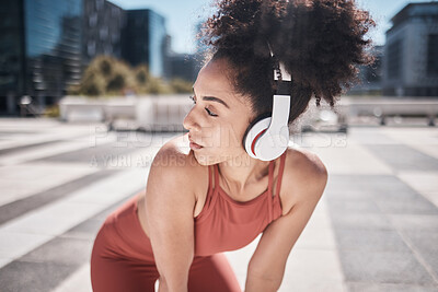Buy stock photo Black woman, fitness and listening to music in the city on a break from running exercise or workout. African American woman runner with headphones for sports training or audio track in the outdoors