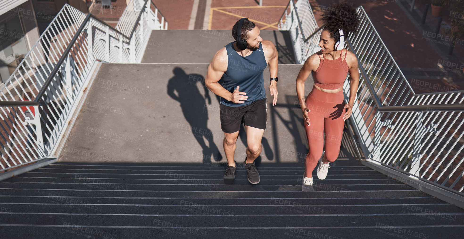 Buy stock photo Fitness, stairs and city with a diversity couple training for sports, cardio or endurance outdoor together. Workout, health and exercise with a man and woman athlete running up a staircase from above