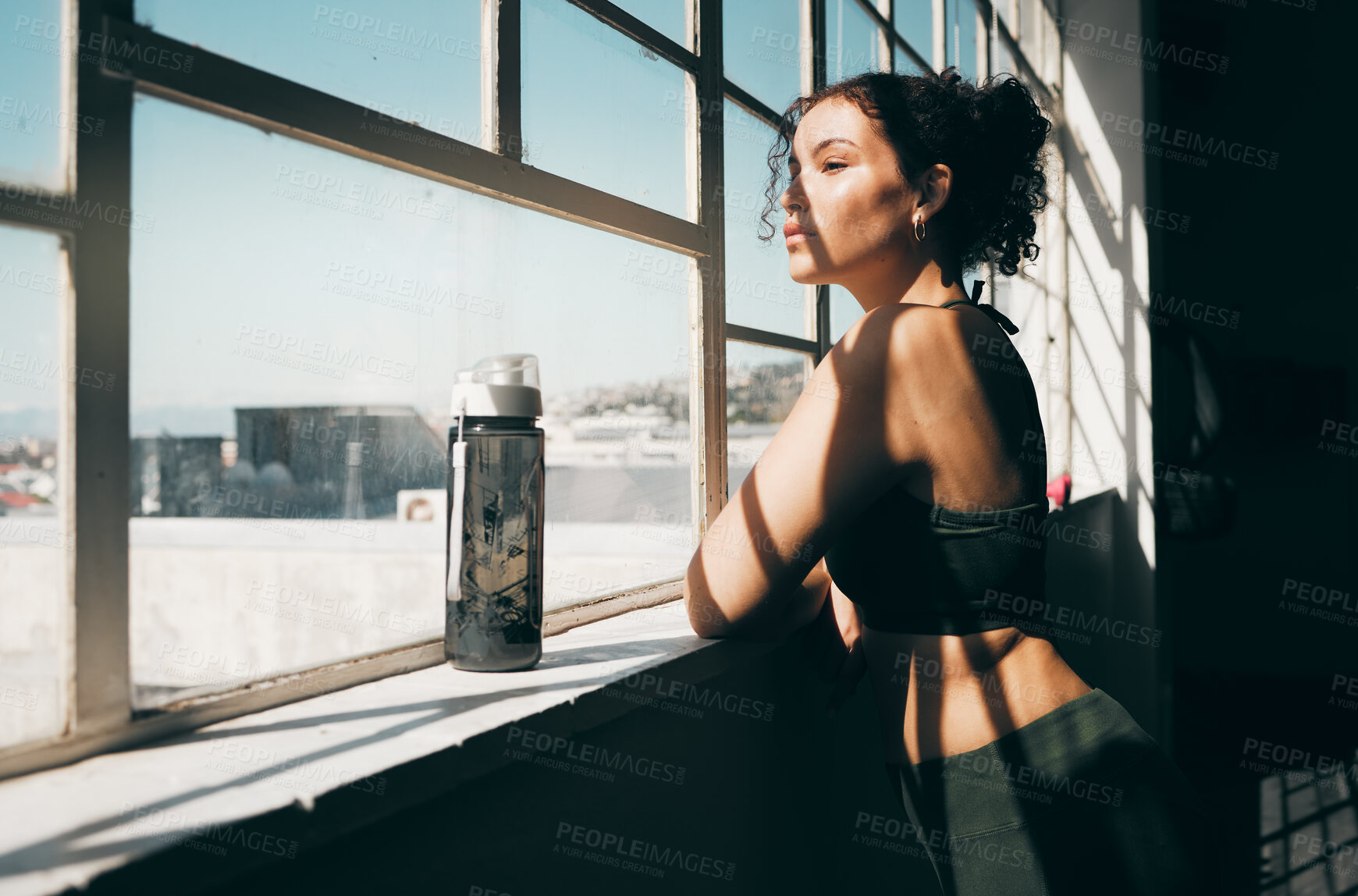 Buy stock photo Window, fitness and relax with a sports woman looking at the view during a break in the gym for exercise. Health, wellness and training with a female athlete taking a break from her studio workout