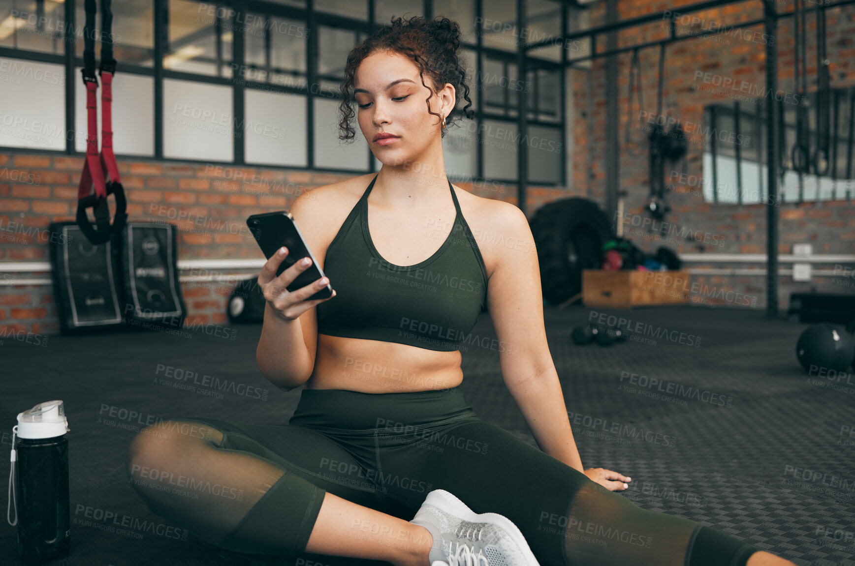 Buy stock photo Woman, fitness and phone at gym for a workout, training and body wellness with a mobile app. Young sports female with smartphone for progress, performance and communication for a healthy lifestyle