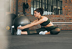 Fitness, exercise and a woman stretching at gym during warm up workout and training for health and wellness. Sports female or athlete on ground to stretch legs to be flexible, balance and healthy