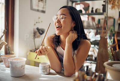 Buy stock photo Happy creative asian woman, art and smile for pottery small business startup in ceramic design. Artistic Japanese female smiling in happiness for arts and crafts holding paint brush for creativity