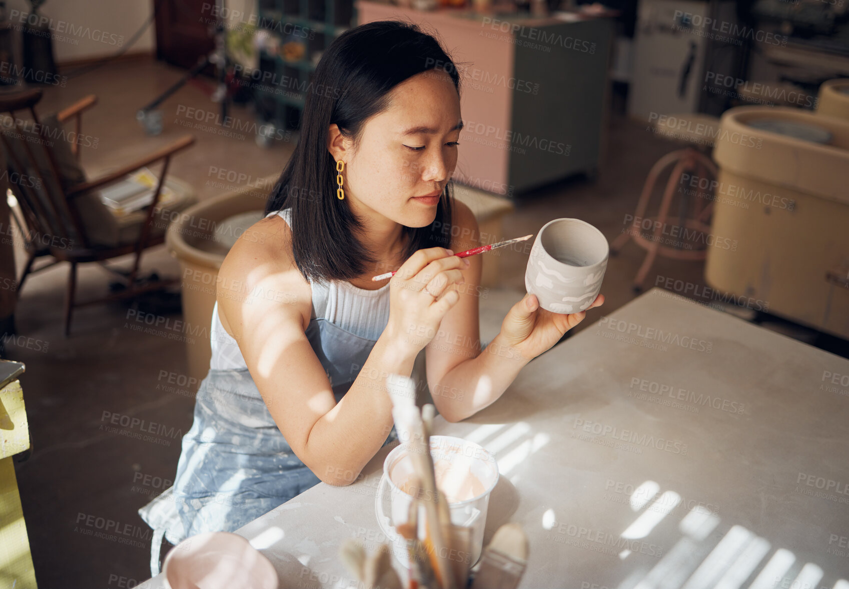 Buy stock photo Pottery, art and ceramics with an asian woman in a studio for design or a creative hobby as an artisan. Manufacturing, pattern and artist with a female potter sitting in her workshop  as a sculptor