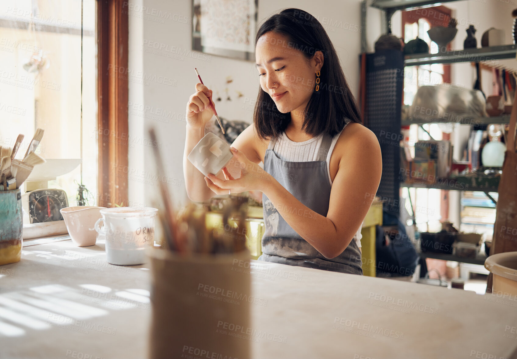 Buy stock photo Pottery, art and creative with an asian woman in a studio for design or ceramics hobby as an artisan. Manufacturing, pattern and artist with a female potter sitting in her workshop  as a sculptor