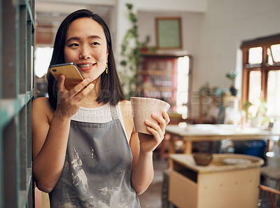 Buy stock photo Pottery, phone call and coffee with an asian woman recording a vote note or message in her workshop. Communication, drink and talking with a female designer or artisan in her studio to design