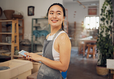 Buy stock photo Tablet, small business and woman in pottery workshop for ceramic startup, research and online website. Creative art, ecommerce and asian lady with tech to sell clay, sculpture and handmade products