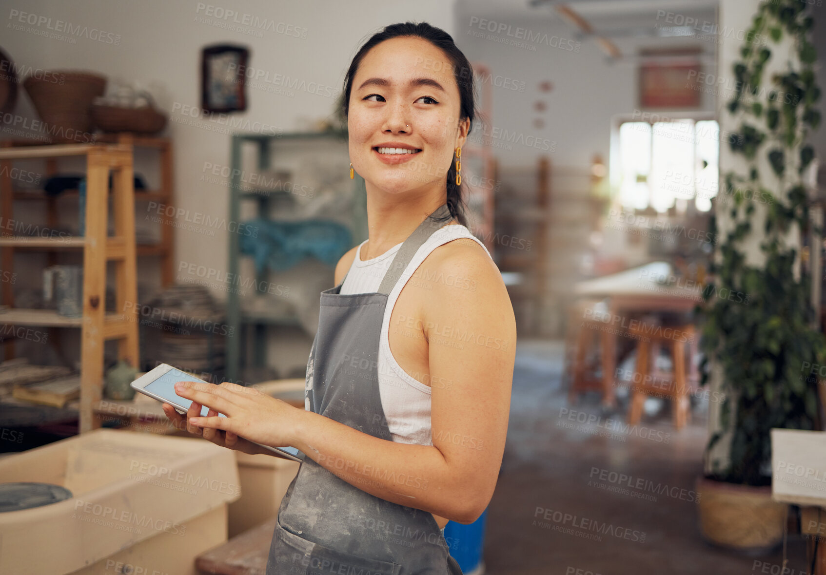 Buy stock photo Tablet, small business and woman in pottery workshop for ceramic startup, research and online website. Creative art, ecommerce and asian lady with tech to sell clay, sculpture and handmade products