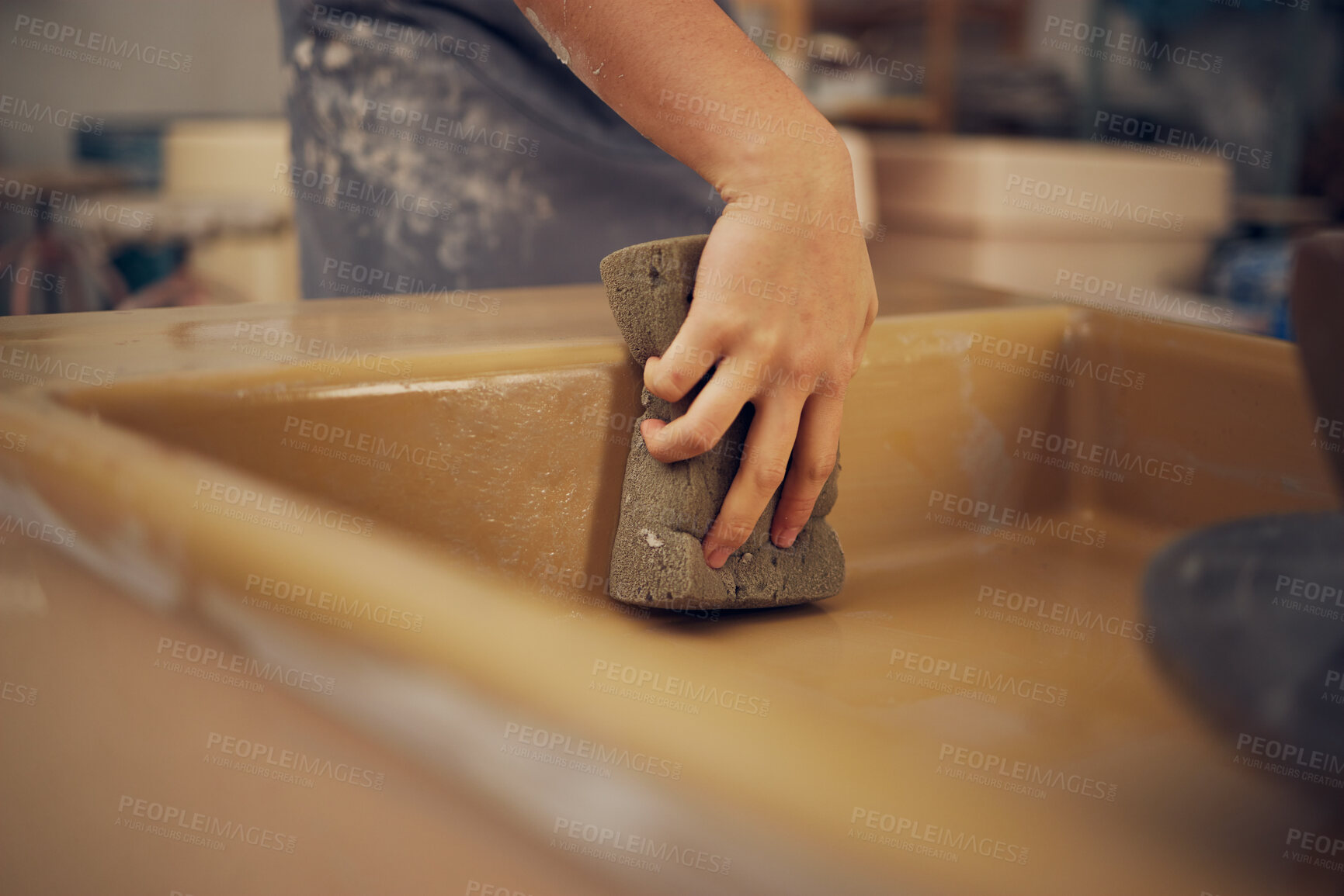 Buy stock photo Hand, pottery and sponge with a woman in her workshop or studio to design or manufacture creative ceramic art. Manufacturing, product and cleaning with a female potter wiping a mold while sculpting