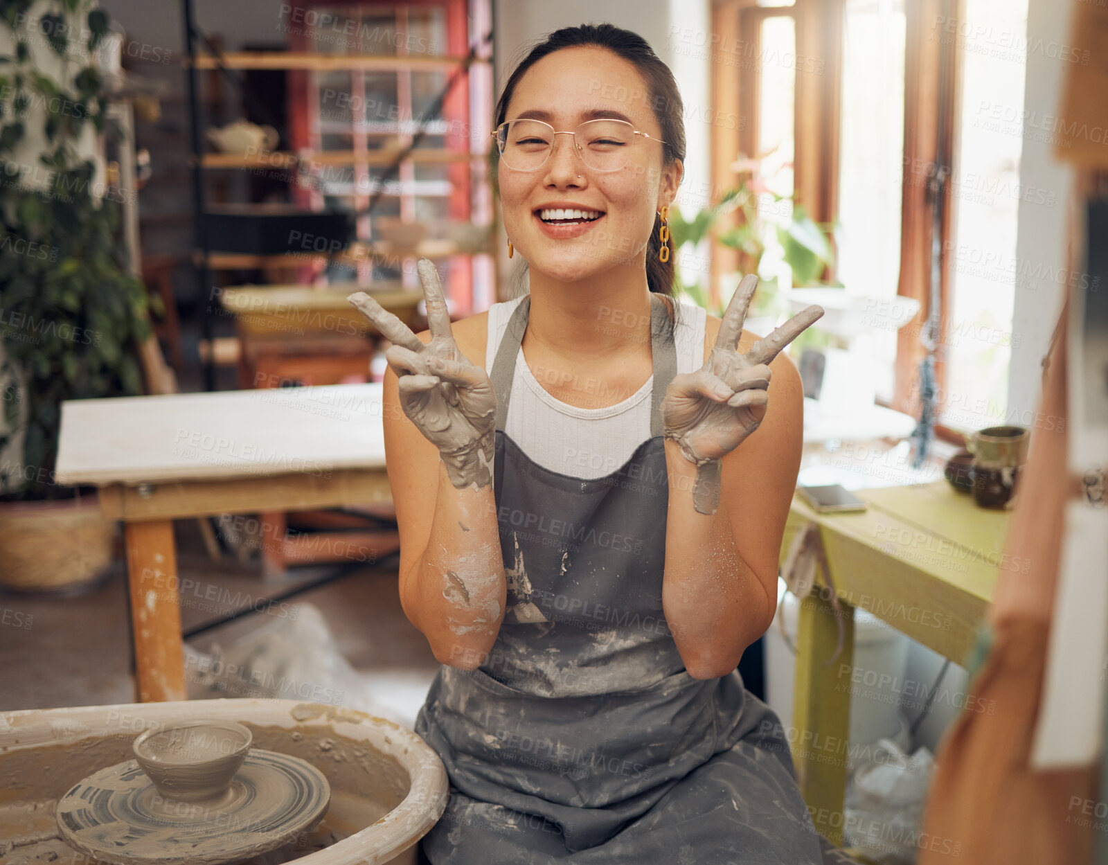 Buy stock photo Pottery, peace and clay hands portrait of woman in workshop for small business art class. Asian person with happy emoji for wheel production or spinning as creative motivation, support and success.
