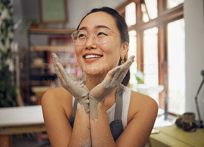 Buy stock photo Hands, face and dirty with an asian woman pottery professional sitting in her studio or workshop. Art, design and creative with a female designer or potter working in her clay or ceramics startup