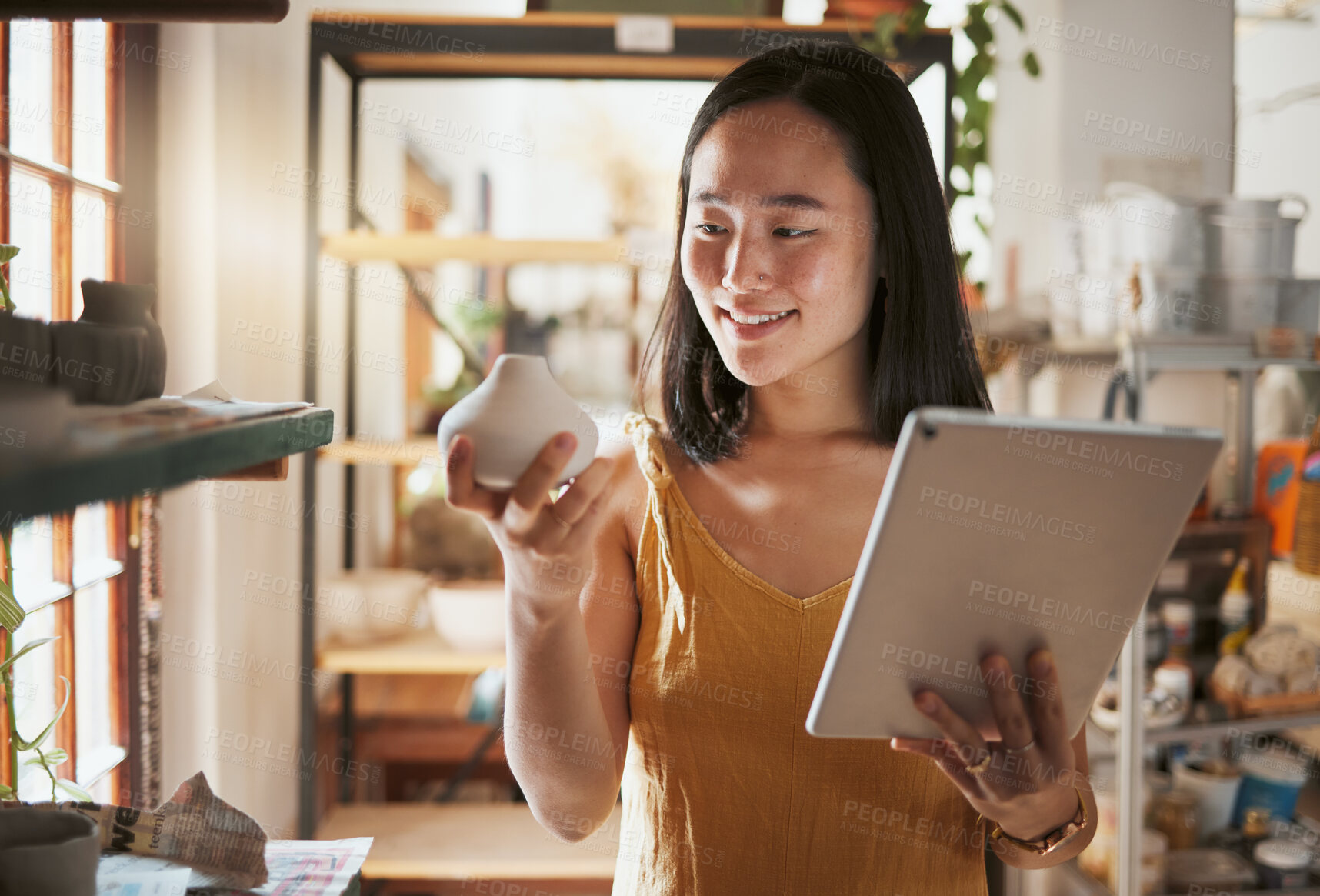 Buy stock photo Creative asian woman, tablet and smile for pottery business, checking inventory or pricing at workshop. Happy Japanese female smiling holding touchscreen with pot art for quality check or startup