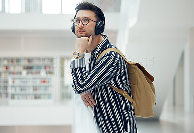 Buy stock photo Thinking, headphones and library student at university, college or academy idea for research, learning and knowledge. Study, education and creative, geek man listening to audio for school inspiration