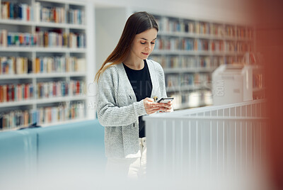 Buy stock photo Library, phone and woman student networking on social media, mobile app or internet in college. Bookstore, knowledge and young female typing or reading a text message on her cellphone at university.