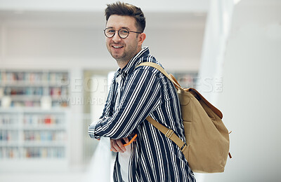 Buy stock photo Portrait, library and student at university, college or academy for research, learning and knowledge with smile for scholarship. Study, education and creative, geek man with backpack and school goals