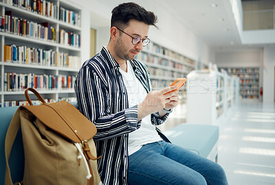 Buy stock photo Library, university and man with phone on sofa for education, research and checking social media. Networking, knowledge and male student on smartphone, mobile app and website in college bookstore