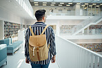 Backpack, library and study with a man student walking in a university bookstore for education or learning. Back, college and research with a male pupil taking a walk in search of reading books