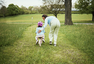 Buy stock photo Mother, girl and learning with bicycle in park with love, bonding or happy by grass field on holiday. Mama, kid and teaching, cycling and bike on outdoor adventure, woods or backyard garden in nature