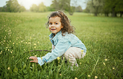 Buy stock photo Girl child, smile and flowers in park, outdoor and learning for plants in backyard, field or woods. Young female kid, picking flower and portrait on grass lawn, spring or exploring ground by forest