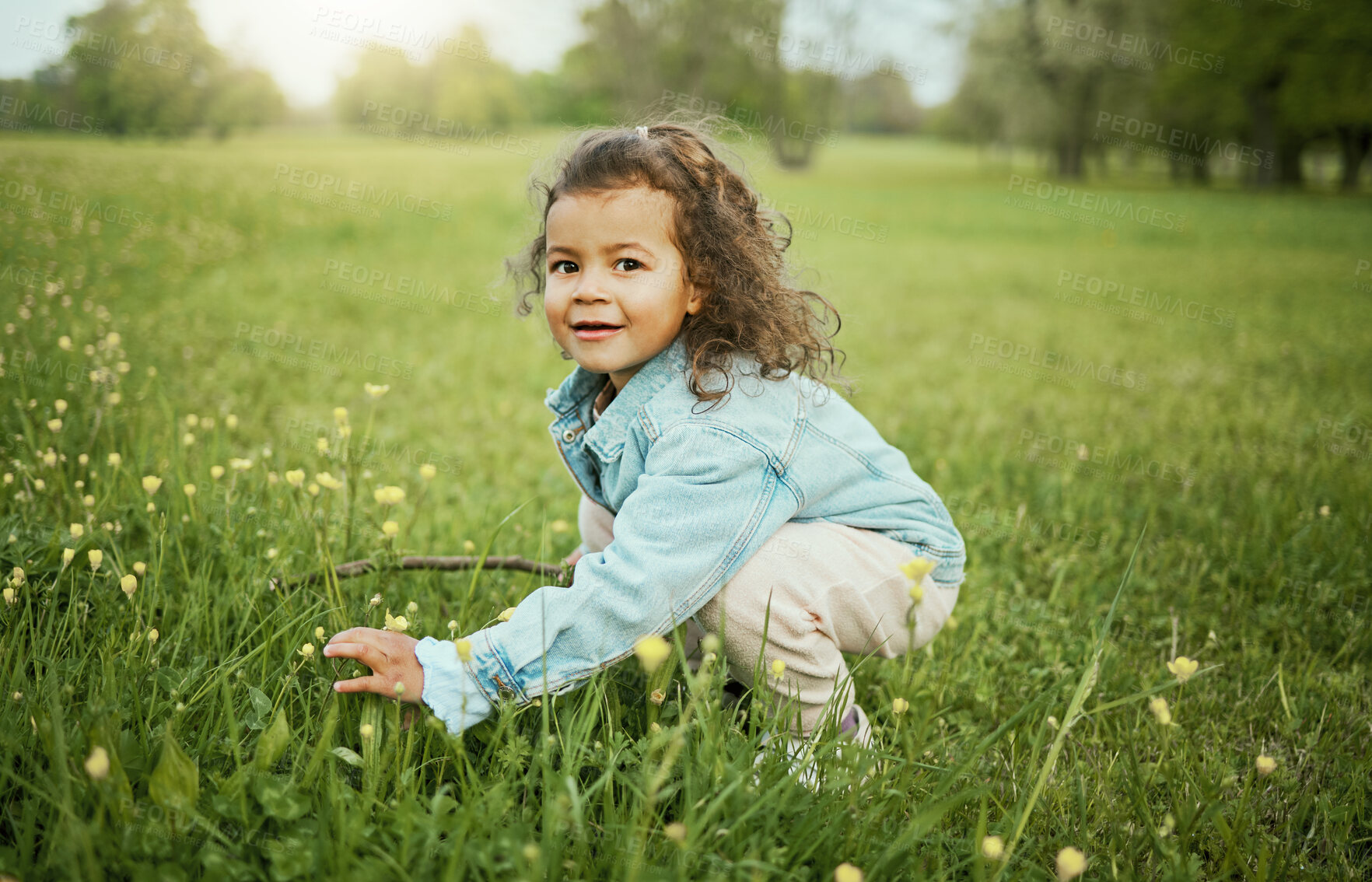 Buy stock photo Girl child, smile and flowers in park, outdoor and learning for plants in backyard, field or woods. Young female kid, picking flower and portrait on grass lawn, spring or exploring ground by forest