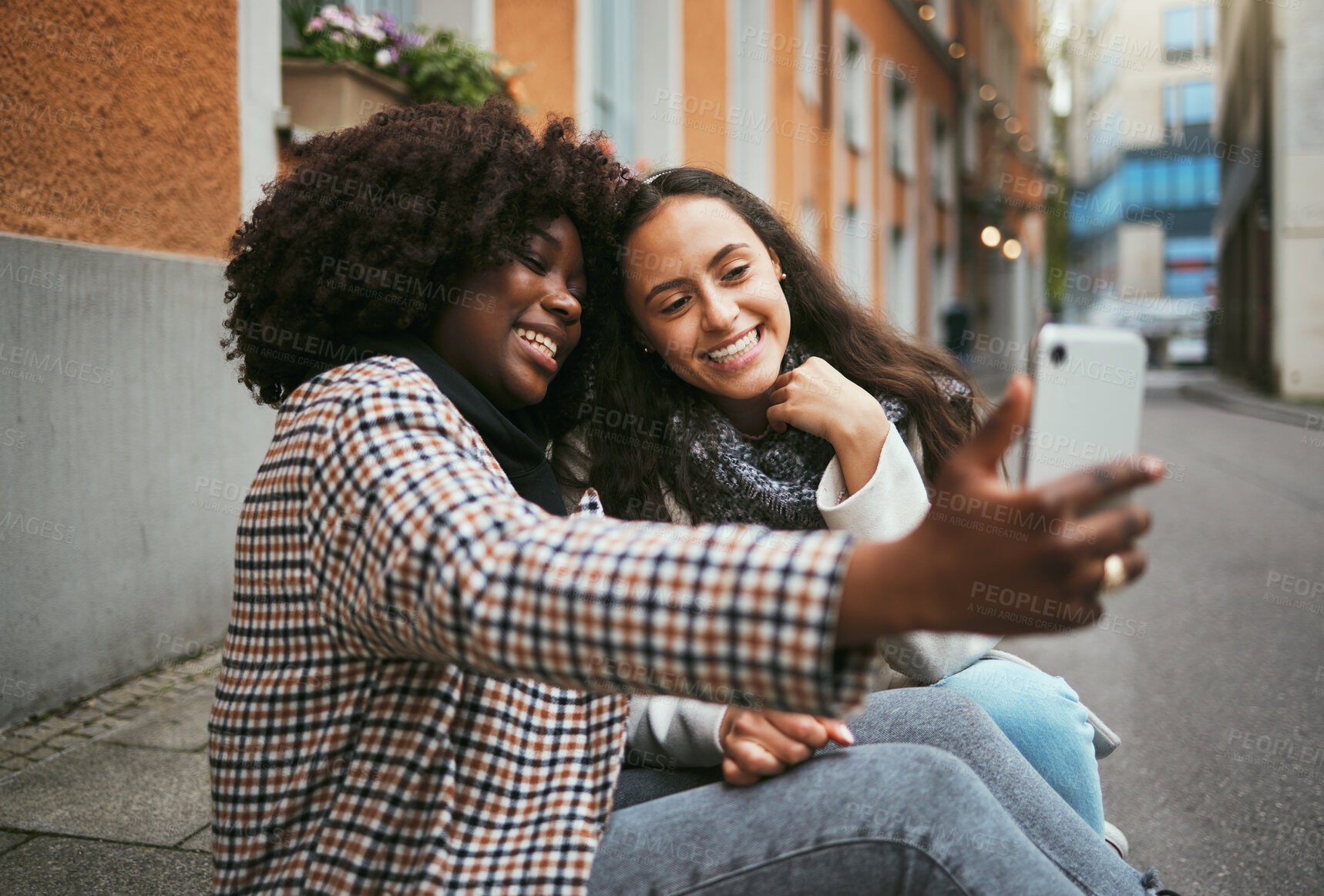 Buy stock photo City, friends and women take selfie with phone and sitting on sidewalk laughing and happy together. Photo, video call and black woman with girl friend with urban fun and social media profile picture.