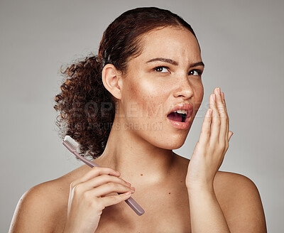 Buy stock photo Woman, bad breath and smelling mouth for dental problem, odor and poor oral health in hand. Female with toothbrush for brushing teeth and self care for halitosis, cavity or decay on grey background