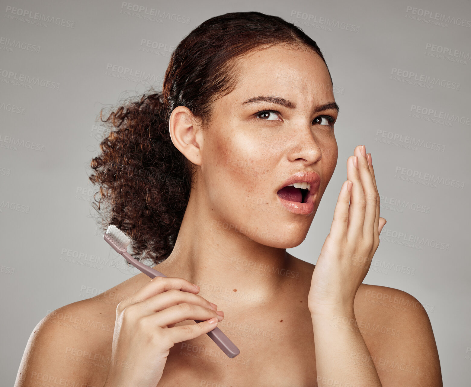 Buy stock photo Woman, bad breath and smelling mouth for dental problem, odor and poor oral health in hand. Female with toothbrush for brushing teeth and self care for halitosis, cavity or decay on grey background