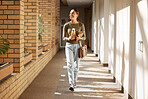 Woman, student and university hallway with a person walking ready for learning and study. Smile, college and back to school happiness of a female tutor on campus going to class happy and alone