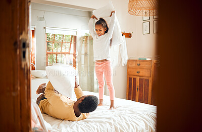 Buy stock photo Pillow fight, home and family bonding with a father and child having fun in a bedroom. Happiness, love and parent care of a dad with a young girl in the morning happy and play fighting on a bed