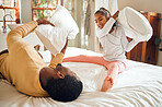Happy pillow fight, father and child on bed playing, bonding and crazy fun for dad and daughter time in home. Family, love and playful energy, black man with girl hitting and laughing in bedroom.