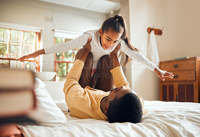 Buy stock photo Father, child and playing on bed flying for fun quality bonding time together indoors at home. Happy dad holding daughter in air with knees and arms in bedroom for playful relationship at the house