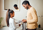 Black family, children or cleaning with a father and daughter in the bathroom of their home to dry hands. Kids, love and hygiene with a man and girl in a house for their morning routine together