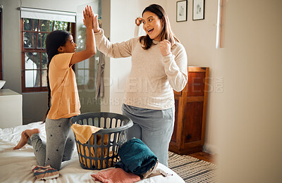Buy stock photo Mother, child and high five for laundry basket, housework or helping with chores together at home. Happy mom and daughter celebrating for clean clothing, washing or victory for done or finished work