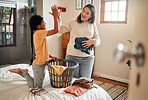 Cleaning, high five and child and mother doing laundry clothes, house work and fold clean fabric. Love bond, home bedroom or happy family kid with basket container and celebrate domestic housekeeping