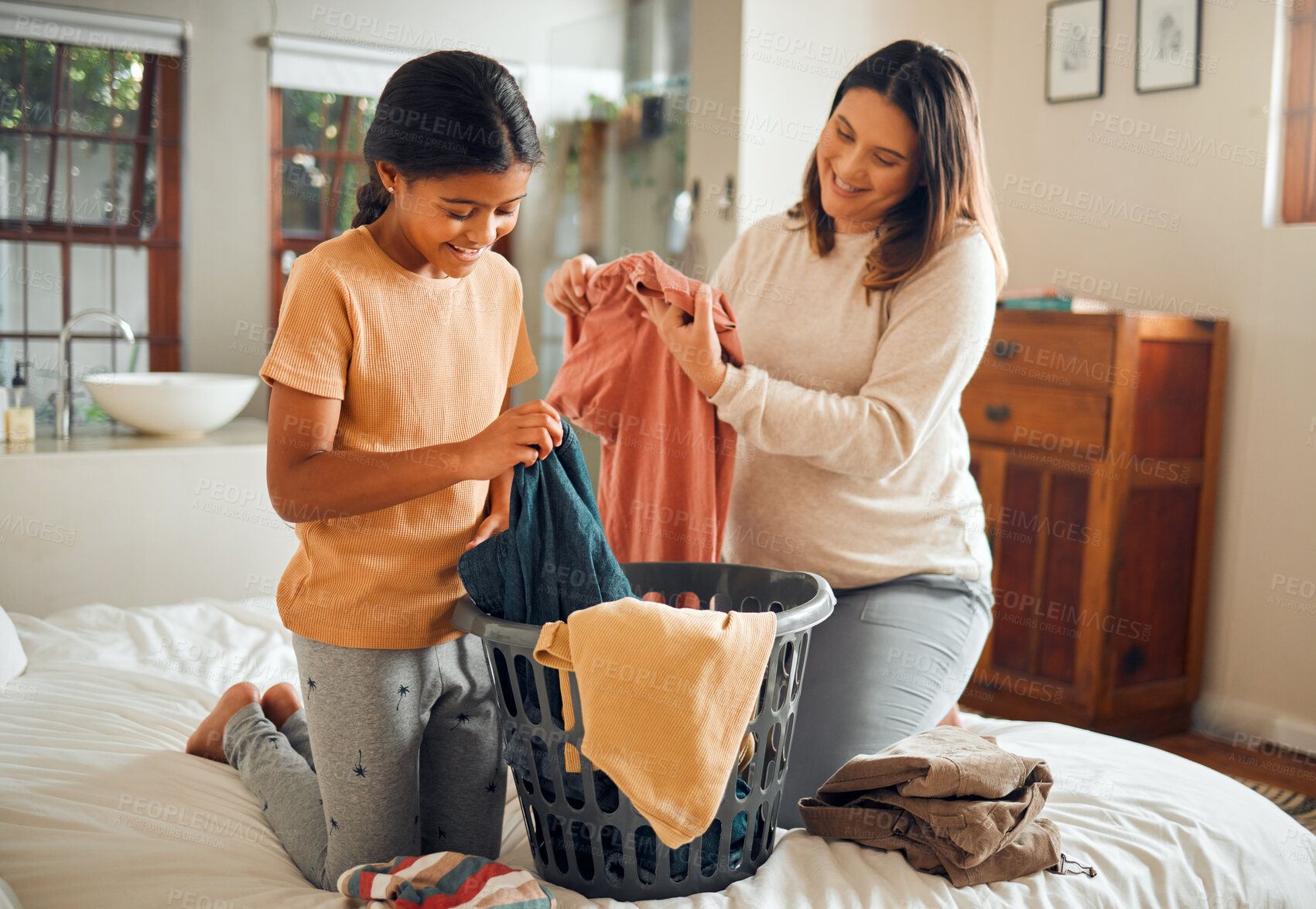 Buy stock photo Laundry, happy mother and child help with house cleaning for pregnant mom with love and care. Clothes, helping girl and working family on a bedroom bed busy with clean clothing fold in a house 