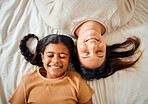 Family, happy and mother and daughter in bed, relax and playing while bonding in their home from above. Resting, mom and girl, smile and lying in a bedroom, playful and having fun indoors on weekend