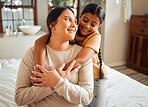 Love, hug and mother and daughter on a bed, bonding and sharing a sweet moment in their home together. Family, happy and girl embrace woman, smile and relax in a bedroom, content and cheerful