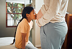 Pregnant, family and love with a daughter kissing the belly of her mother while bonding in the bedroom of their home. Kids, mom and pregnancy with a kiss by an indian girl to the stomach of her mama