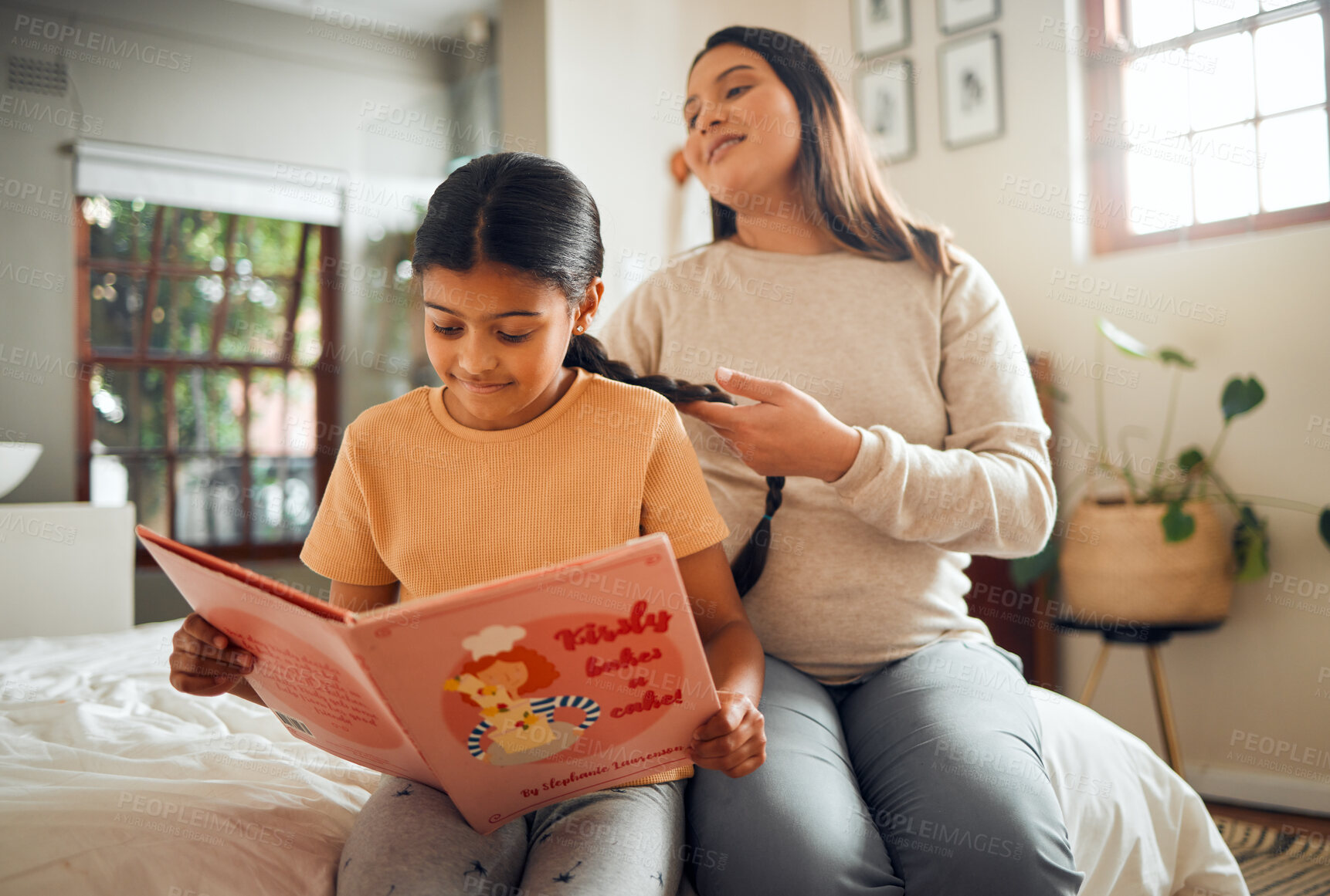 Buy stock photo Family, book or education and a girl reading in a bedroom with her mom playing with her hair in their home. Books, learning and love with a mother and daughter bonding while sitting on a bed together