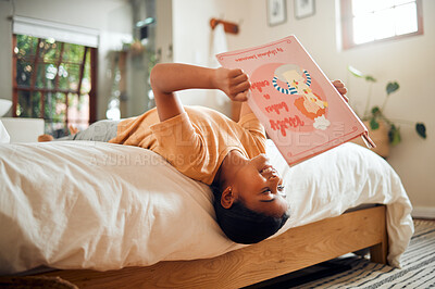 Buy stock photo Happy child reading book on bed for home learning, language education and creative development upside down. Smart, intelligent and Indian kid with English story for fun, relax and holiday activity