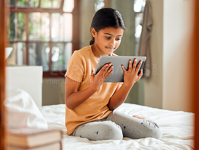 Buy stock photo Little girl, tablet and smile on bed for entertainment, education or learning while relaxing at home. Happy female child enjoying time streaming holding touchscreen for online elearning in bedroom