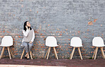 Phone call, interview queue and woman with chairs, recruitment and employment with smile in Japan. Happy person sitting on chair with smartphone, smiling and talking  with job opportunity for people.
