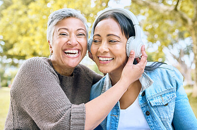 Buy stock photo Music, happy and portrait of women in a park streaming a funny podcast, audio and song in India. Laughing, smile and senior friends with headphones listening to a comic sound or radio in nature