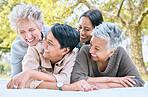 Funny women and retirement friends at park laughing for joke, bonding and wellness lifestyle. Happy, care and smile of senior people in interracial friendship in nature together.

