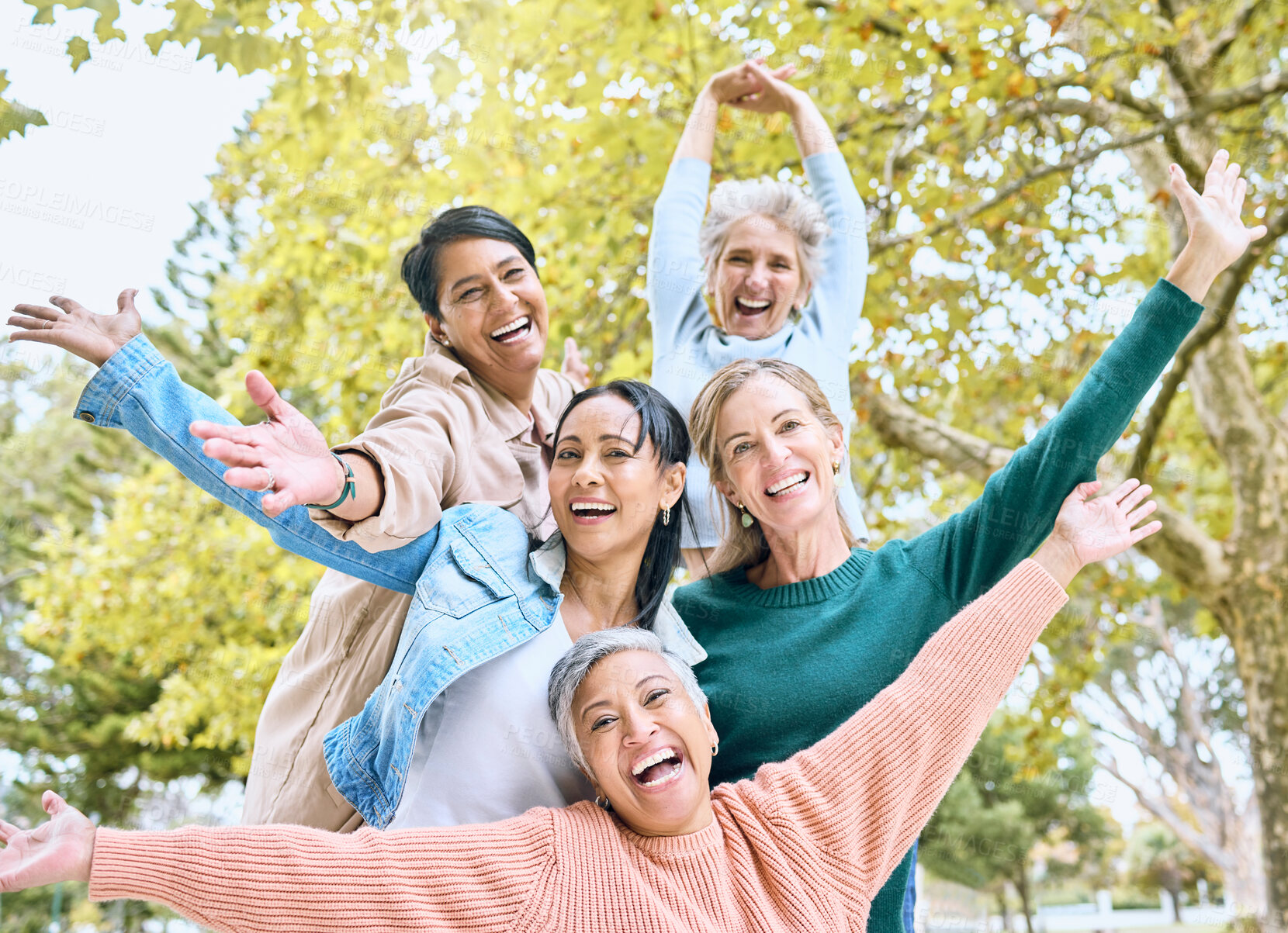 Buy stock photo Senior retirement, portrait and hands up in fun game, goofy activity or silly energy for comic profile picture on social media. Smile, happy women and diversity elderly friends in nature park bonding